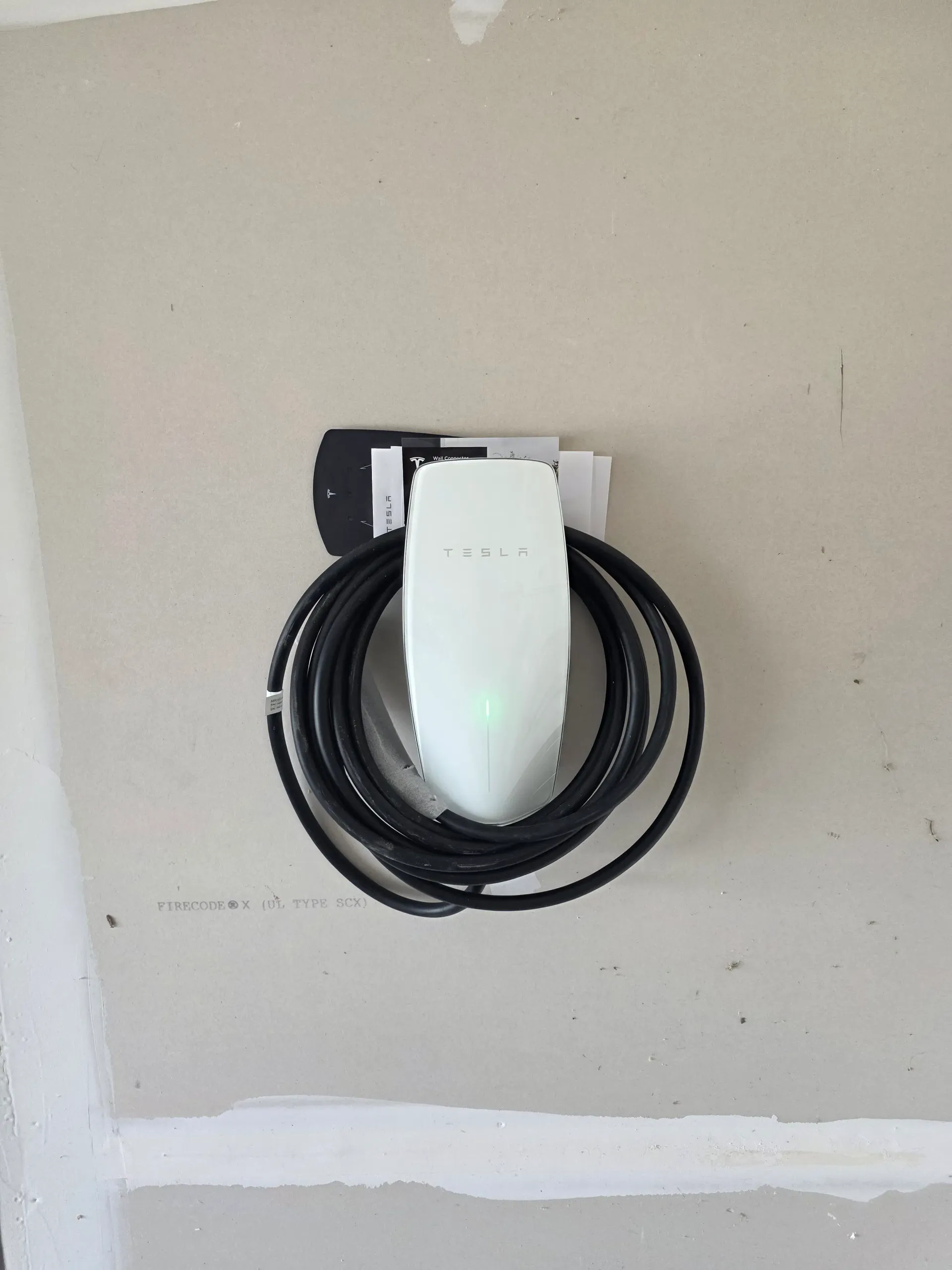 Tesla Wall Connector mounted on a residential wall in Fauquier County, Virginia, with the charging cable coiled